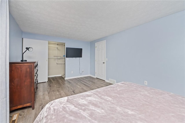 24 Huntsman, Webster, NY 14580 - bedroom with wood finished floors, a textured ceiling, and a walk in closet