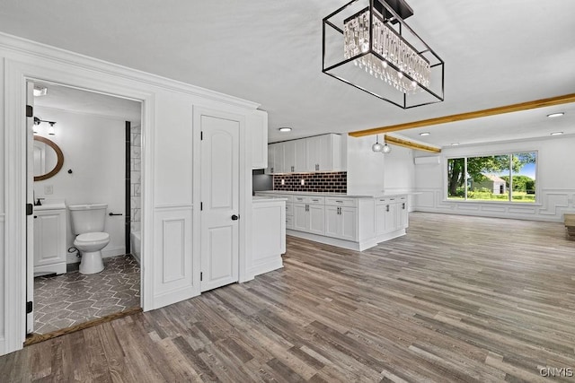 8953 Bushnell Shore Rd, Sullivan, NY 13037 - unfurnished living room featuring a chandelier, wood finished floors, a wall unit AC, and ornamental molding