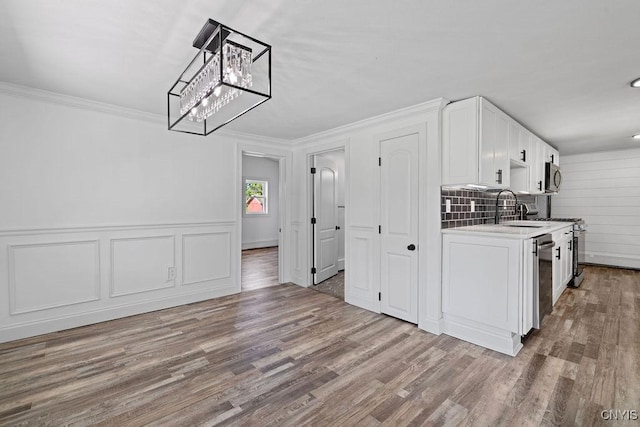 8953 Bushnell Shore Rd, Sullivan, NY 13037 - kitchen featuring white cabinets, wood finished floors, stainless steel appliances, light countertops, and a chandelier
