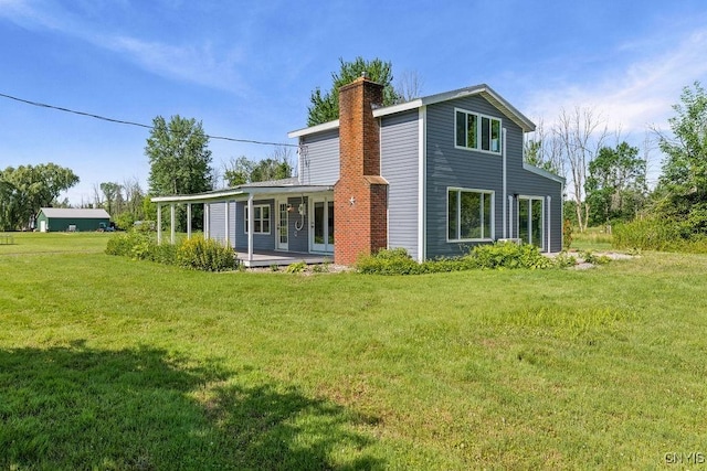 8953 Bushnell Shore Rd, Sullivan, NY 13037 - rear view of property featuring a chimney, a lawn, and a patio area