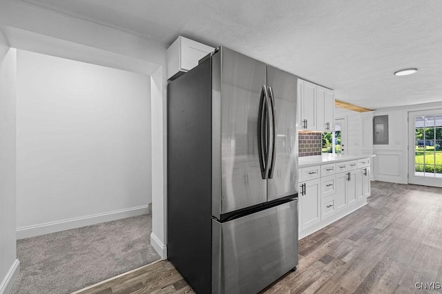8953 Bushnell Shore Rd, Sullivan, NY 13037 - kitchen with freestanding refrigerator, light countertops, white cabinets, wood finished floors, and electric panel
