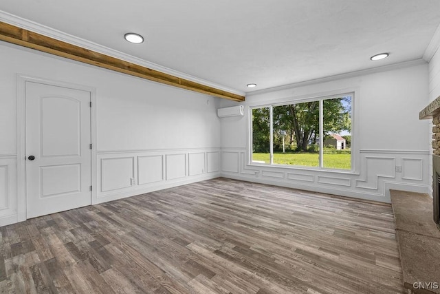 8953 Bushnell Shore Rd, Sullivan, NY 13037 - unfurnished room featuring ornamental molding, a wall unit AC, wood finished floors, a wainscoted wall, and a stone fireplace