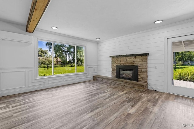 8953 Bushnell Shore Rd, Sullivan, NY 13037 - unfurnished living room with a wall unit AC, plenty of natural light, wood finished floors, a stone fireplace, and recessed lighting