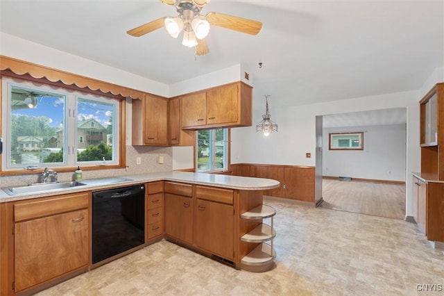 178 Wainwright Ave, Syracuse, NY 13208 - kitchen with dishwasher, a peninsula, light countertops, a wainscoted wall, and brown cabinetry