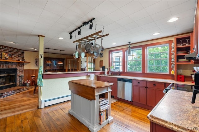 6767 Stauber Rd, Summerhill, NY 13073 - kitchen with stainless steel dishwasher, baseboard heating, light wood-type flooring, a fireplace, and recessed lighting