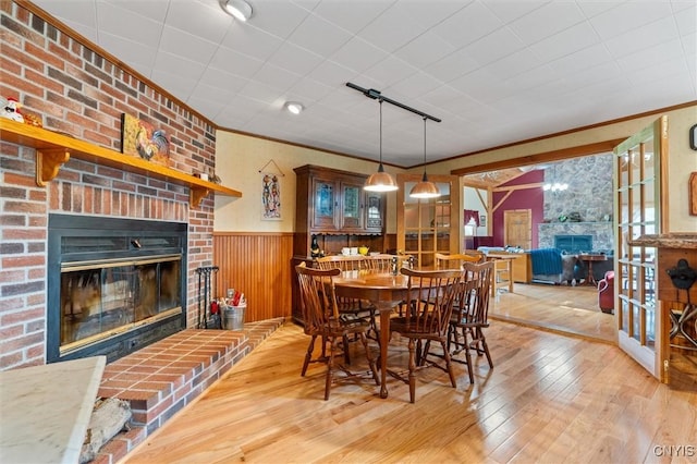 6767 Stauber Rd, Summerhill, NY 13073 - dining space with a fireplace, hardwood / wood-style floors, wainscoting, and ornamental molding