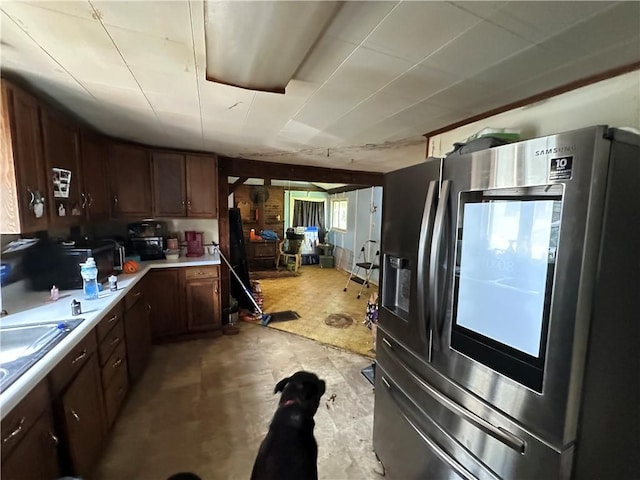 135 William St, Palmyra, NY 14522 - kitchen with stainless steel fridge, light countertops, dark brown cabinets, and light floors
