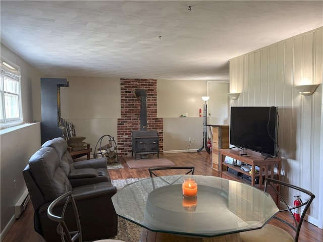 1292 Gassner Rd, Junius, NY 13165 - living room featuring a wood stove, wood finished floors, and baseboard heating