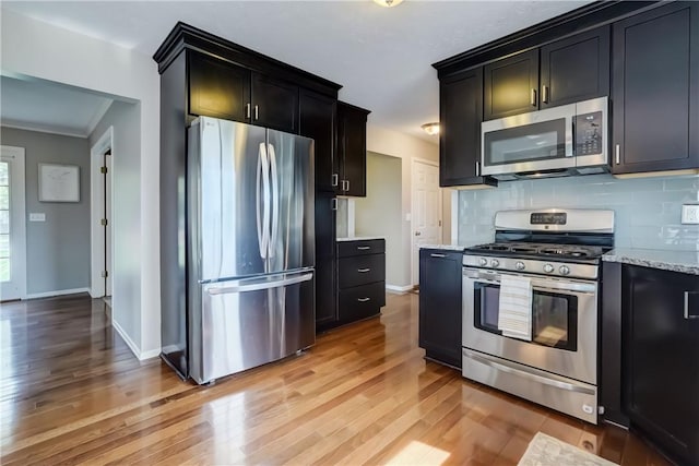 1125 Shoecraft Rd, Webster, NY 14580 - kitchen featuring appliances with stainless steel finishes, light wood-type flooring, dark cabinets, and backsplash