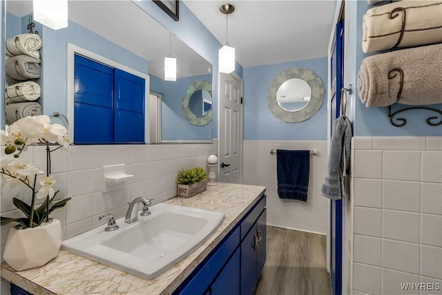 204 French Lea Rd, West Seneca, NY 14224 - bathroom featuring tile walls, vanity, wood finished floors, and a wainscoted wall