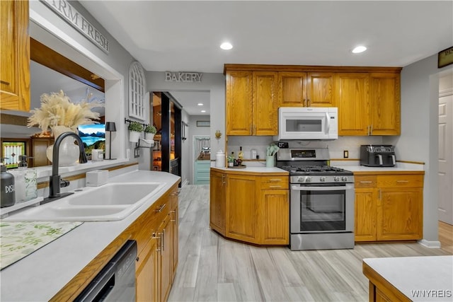 204 French Lea Rd, West Seneca, NY 14224 - kitchen featuring white microwave, gas stove, light countertops, light wood-type flooring, and brown cabinets