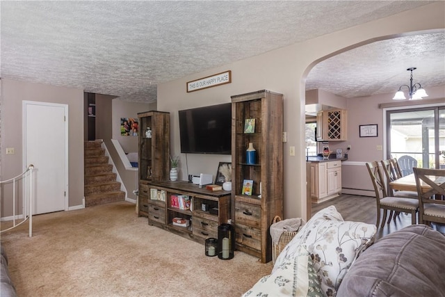 477 Pine Circle Ext, Big Flats, NY 14845 - living room featuring a textured ceiling, a chandelier, arched walkways, a baseboard heating unit, and light carpet