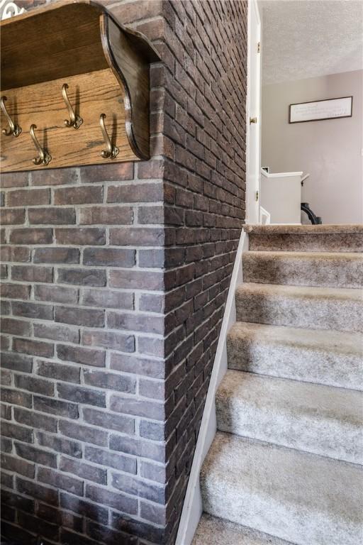 477 Pine Circle Ext, Big Flats, NY 14845 - stairs featuring a textured ceiling and brick wall