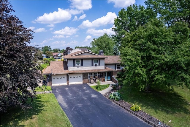 477 Pine Circle Ext, Big Flats, NY 14845 - traditional home with asphalt driveway, brick siding, a garage, a front yard, and a porch
