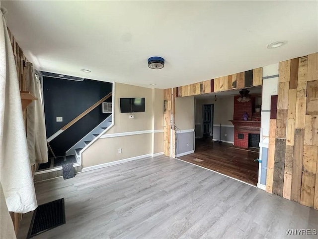 7 High St, Lyons, NY 14489 - unfurnished living room with ceiling fan, a fireplace, dark wood-style flooring, and stairway