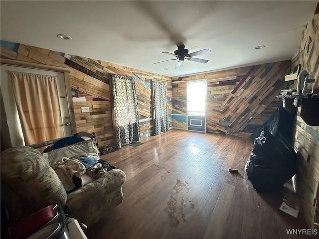7 High St, Lyons, NY 14489 - living area featuring wooden walls, a ceiling fan, and hardwood / wood-style floors