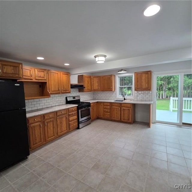 5709 Merry St, Verona, NY 13478 - kitchen with freestanding refrigerator, stainless steel range with gas stovetop, light countertops, brown cabinets, and recessed lighting