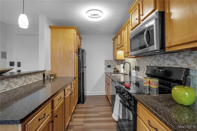 849 Delaware Ave Unit 404, Buffalo, NY 14209 - kitchen featuring black appliances, light wood-style floors, tasteful backsplash, and dark stone countertops