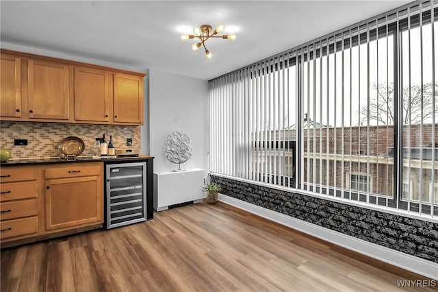 849 Delaware Ave Unit 404, Buffalo, NY 14209 - indoor wet bar featuring beverage cooler, light wood finished floors, decorative backsplash, and a chandelier