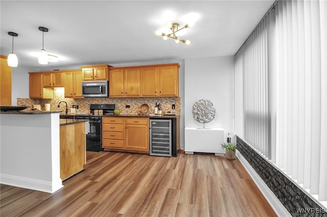 849 Delaware Ave Unit 404, Buffalo, NY 14209 - kitchen featuring black gas stove, beverage cooler, stainless steel microwave, light wood-style floors, and dark countertops
