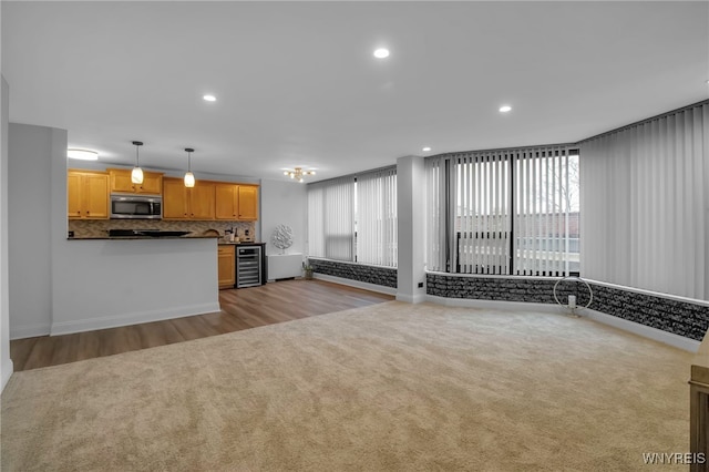849 Delaware Ave Unit 404, Buffalo, NY 14209 - kitchen featuring stainless steel microwave, beverage cooler, healthy amount of natural light, tasteful backsplash, and recessed lighting