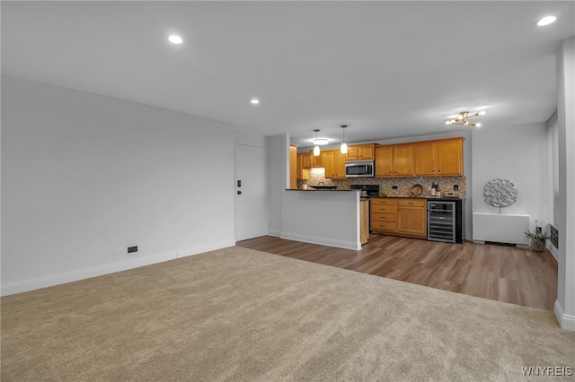 849 Delaware Ave Unit 404, Buffalo, NY 14209 - kitchen with stainless steel microwave, wine cooler, light colored carpet, dark countertops, and backsplash