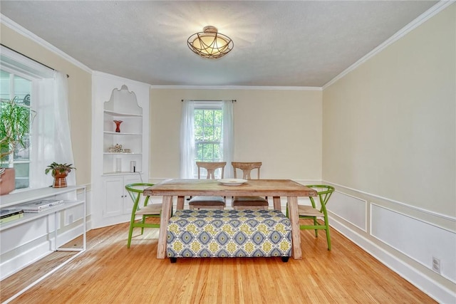 772 Winona Blvd, Irondequoit, NY 14617 - dining room featuring built in shelves, ornamental molding, and light wood finished floors