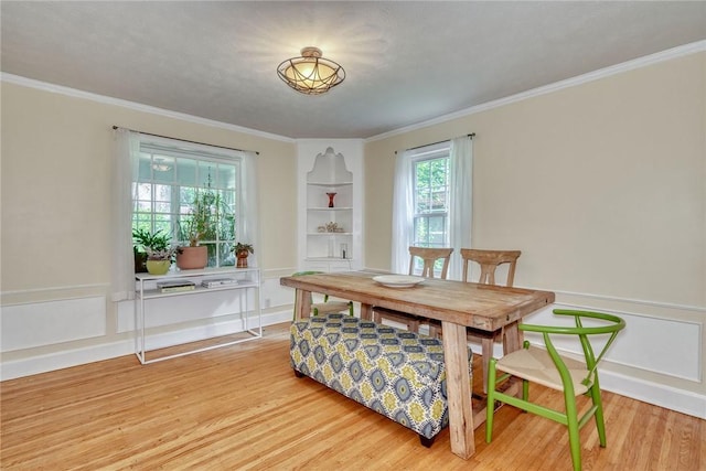 772 Winona Blvd, Irondequoit, NY 14617 - dining area featuring light wood-type flooring, crown molding, and a wainscoted wall
