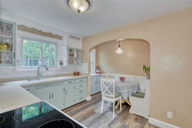 772 Winona Blvd, Irondequoit, NY 14617 - kitchen with light wood-type flooring, decorative backsplash, light countertops, and arched walkways