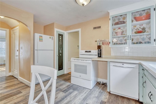 772 Winona Blvd, Irondequoit, NY 14617 - kitchen featuring white appliances, light wood-style floors, light countertops, arched walkways, and glass insert cabinets
