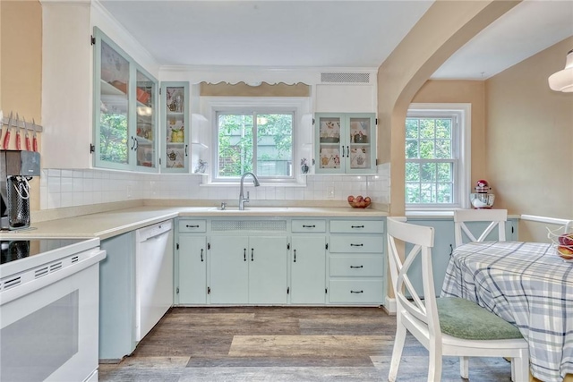 772 Winona Blvd, Irondequoit, NY 14617 - kitchen with white appliances, decorative backsplash, light wood-style flooring, light countertops, and glass insert cabinets