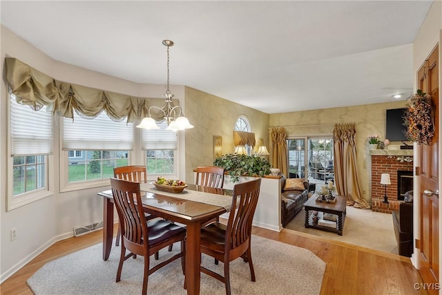 7619 Pico Ln, Lysander, NY 13027 - dining area featuring a chandelier, light wood-type flooring, and a fireplace
