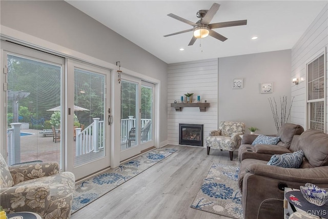 21 Donovan Dr, Oswego, NY 13126 - living room featuring wood finished floors, a ceiling fan, a large fireplace, recessed lighting, and wood walls