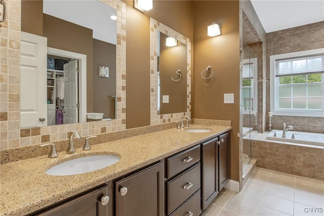 21 Donovan Dr, Oswego, NY 13126 - full bathroom with a shower stall, a bath, double vanity, tile patterned flooring, and a walk in closet