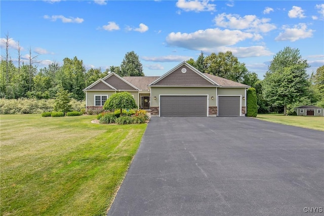 21 Donovan Dr, Oswego, NY 13126 - view of front of property featuring an attached garage, a front yard, driveway, and stone siding