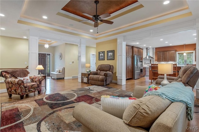 21 Donovan Dr, Oswego, NY 13126 - living room featuring decorative columns, a tray ceiling, light wood finished floors, ornamental molding, and recessed lighting