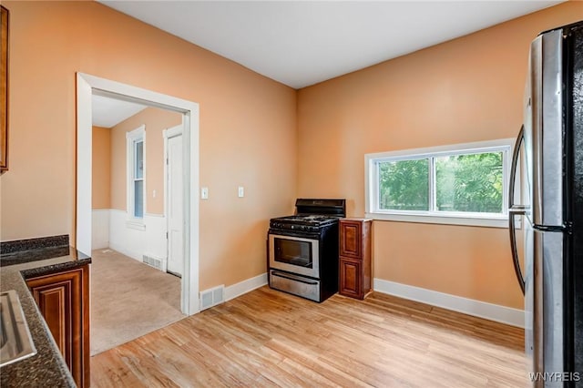 285 E N St Unit S, Buffalo, NY 14204 - kitchen with appliances with stainless steel finishes, light wood-style flooring, brown cabinetry, and dark stone countertops