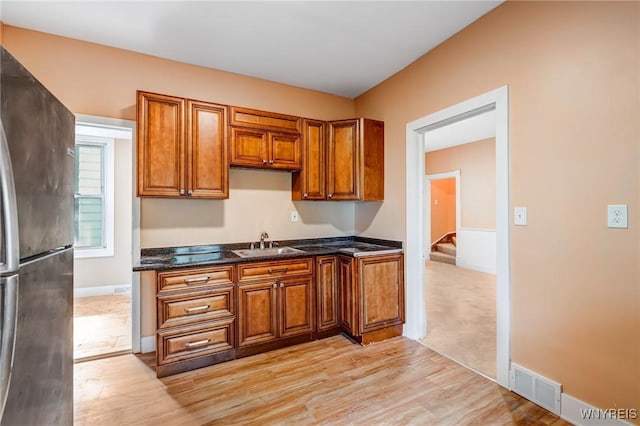 285 E N St Unit S, Buffalo, NY 14204 - kitchen featuring freestanding refrigerator, brown cabinetry, light wood-style flooring, and dark stone counters