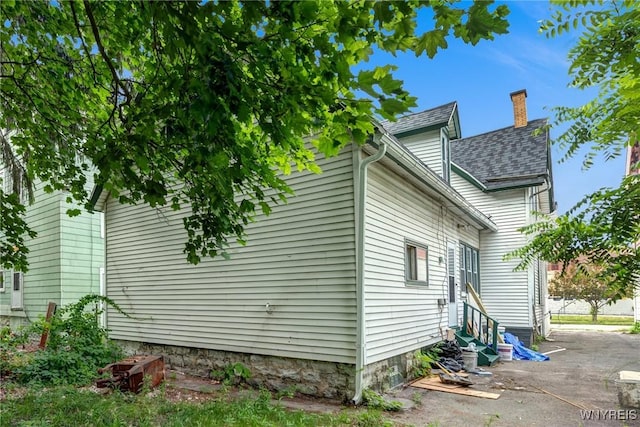 285 E N St Unit S, Buffalo, NY 14204 - view of property exterior with entry steps, roof with shingles, a patio area, and a chimney