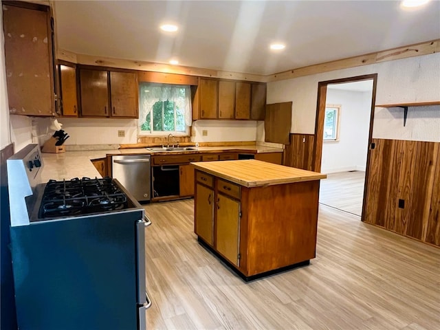 33 E Vanscoter St, Hornell, NY 14843 - kitchen with range with gas stovetop, dishwasher, light wood-type flooring, brown cabinetry, and wood walls