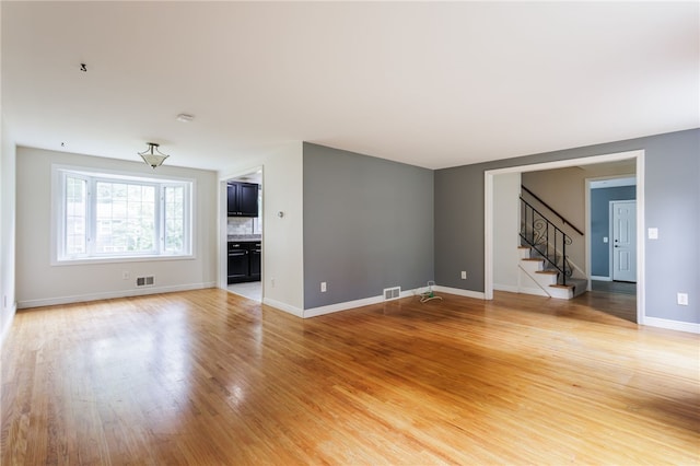 32 White Birch Cir, Chili, NY 14624 - unfurnished living room with stairway and light wood-style flooring