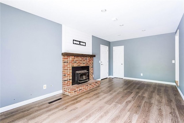 32 White Birch Cir, Chili, NY 14624 - unfurnished living room featuring a wood stove and wood finished floors
