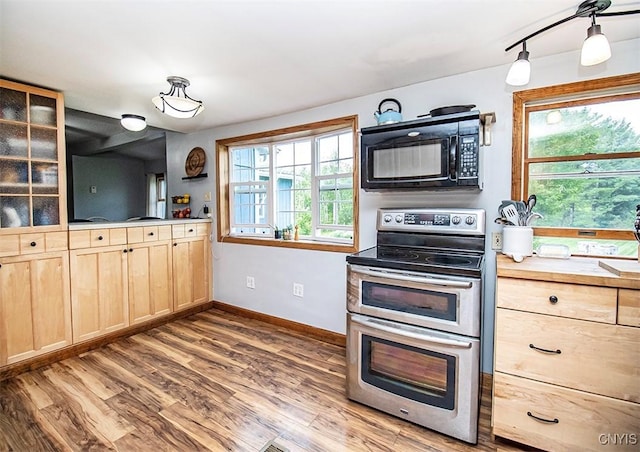 4022 W Milestrip Rd, Fenner, NY 13032 - kitchen with double oven range, black microwave, light brown cabinetry, wood finished floors, and glass insert cabinets