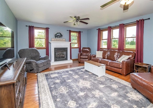 4022 W Milestrip Rd, Fenner, NY 13032 - living area with ceiling fan, a fireplace with raised hearth, and light wood finished floors