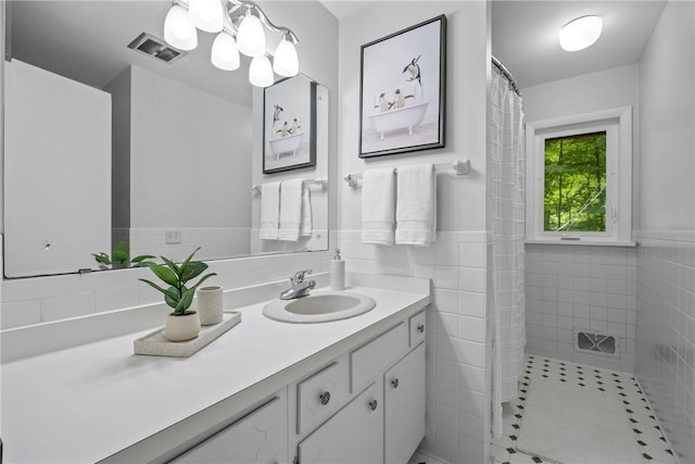 790 Oakridge Dr, Irondequoit, NY 14617 - bathroom with vanity, tile walls, a wainscoted wall, a shower with shower curtain, and a chandelier