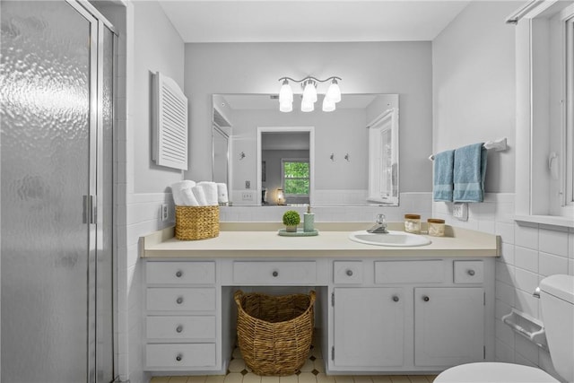790 Oakridge Dr, Irondequoit, NY 14617 - bathroom with a shower stall, vanity, tile walls, and a wainscoted wall