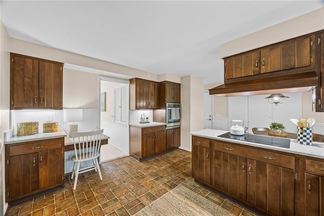 790 Oakridge Dr, Irondequoit, NY 14617 - kitchen featuring black electric cooktop, oven, light countertops, brick patterned floors, and custom exhaust hood