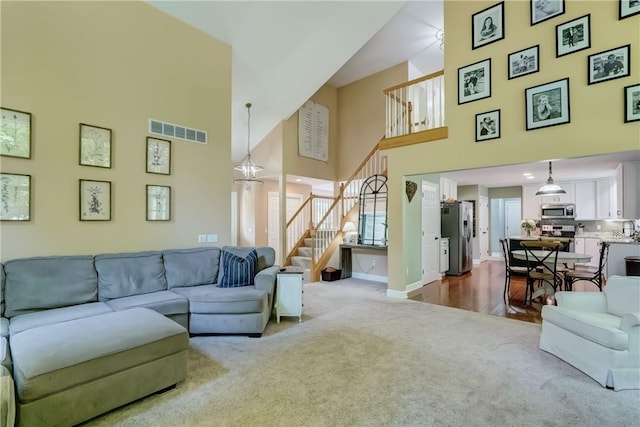 906 Lothario Cir, Webster, NY 14580 - living room featuring dark carpet, stairway, and a towering ceiling
