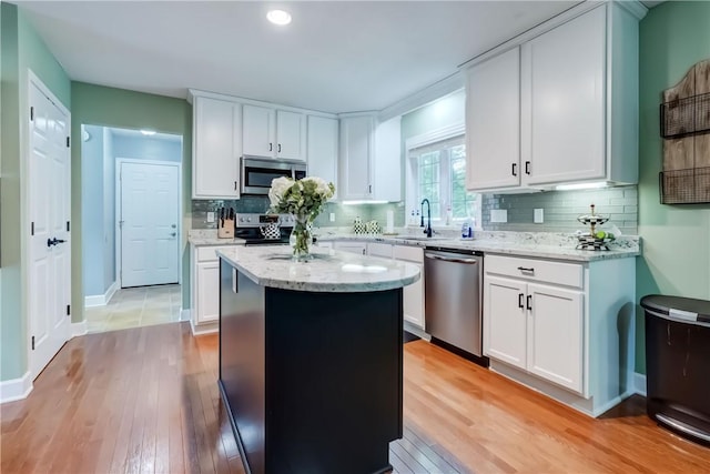 906 Lothario Cir, Webster, NY 14580 - kitchen with stainless steel appliances, a center island, light wood-style floors, and backsplash