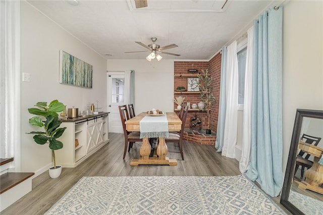 569 Marsh Rd, Pittsford, NY 14534 - dining room with brick wall, ceiling fan, and light wood-style flooring